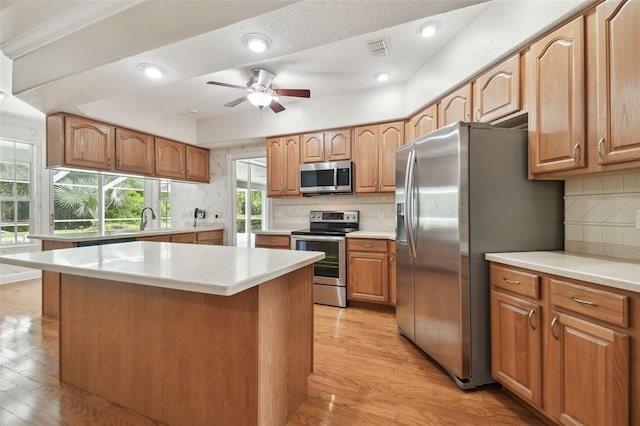 2519 Shipston Ave, New Port Richey, FL 34655 - kitchen with appliances with stainless steel finishes, light wood-type flooring, decorative backsplash, light countertops, and recessed lighting