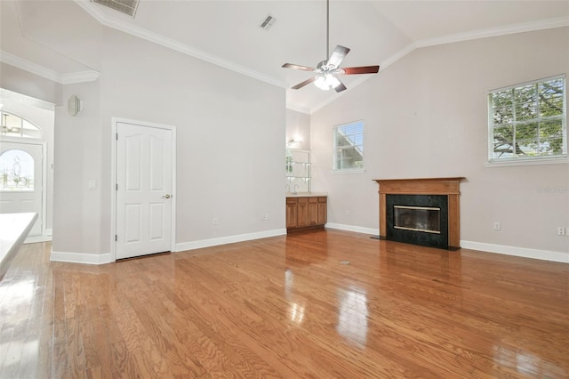 2519 Shipston Ave, New Port Richey, FL 34655 - unfurnished living room featuring plenty of natural light, a ceiling fan, a high end fireplace, high vaulted ceiling, and crown molding
