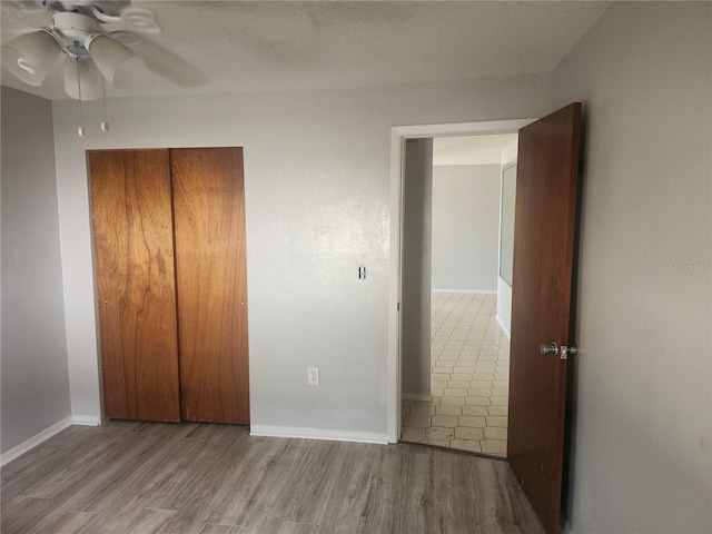 7338 Foxbloom Dr, Port Richey, FL 34668 - unfurnished bedroom featuring wood finished floors, a closet, and a ceiling fan