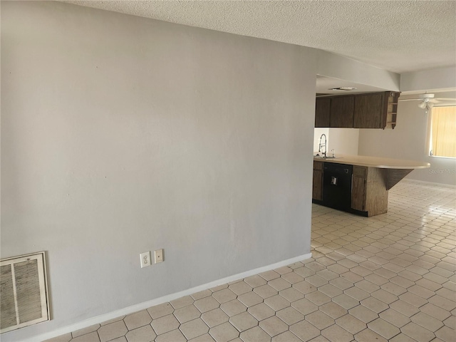 7338 Foxbloom Dr, Port Richey, FL 34668 - kitchen featuring light countertops, a peninsula, a textured ceiling, dark brown cabinets, and a kitchen bar