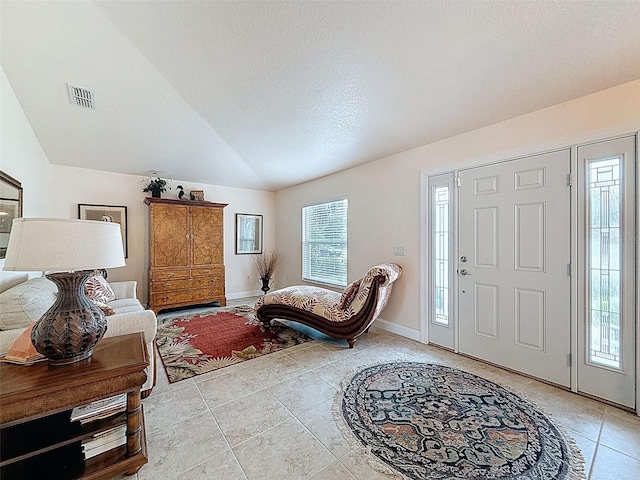 9431 Spring Hill Dr, Spring Hill, FL 34608 - entrance foyer featuring light tile patterned flooring, lofted ceiling, and a textured ceiling