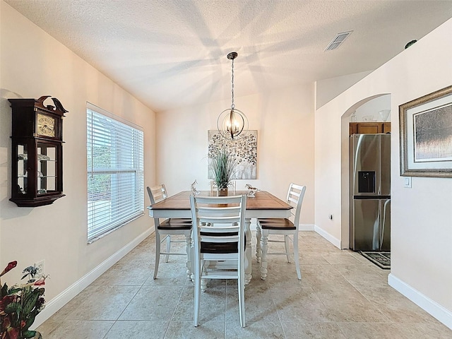 9431 Spring Hill Dr, Spring Hill, FL 34608 - dining area featuring arched walkways, a textured ceiling, and a chandelier