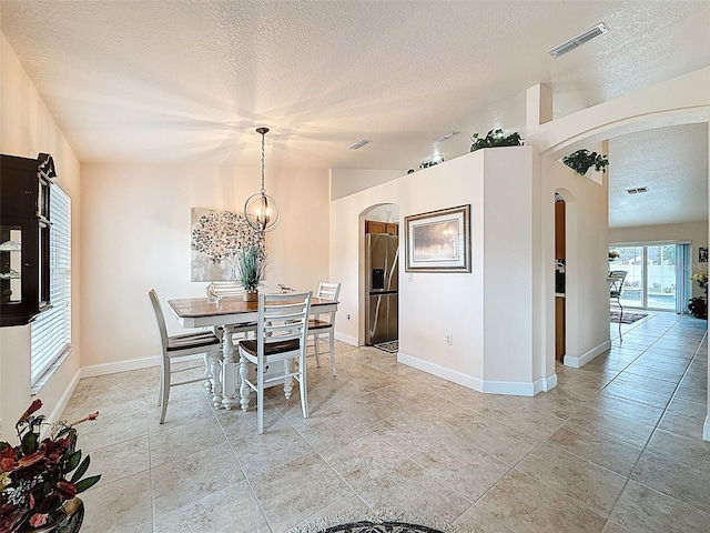 9431 Spring Hill Dr, Spring Hill, FL 34608 - dining room featuring arched walkways, a textured ceiling, and a chandelier