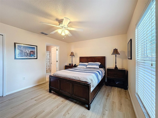 9431 Spring Hill Dr, Spring Hill, FL 34608 - bedroom featuring light wood-style floors, a ceiling fan, a textured ceiling, and ensuite bath