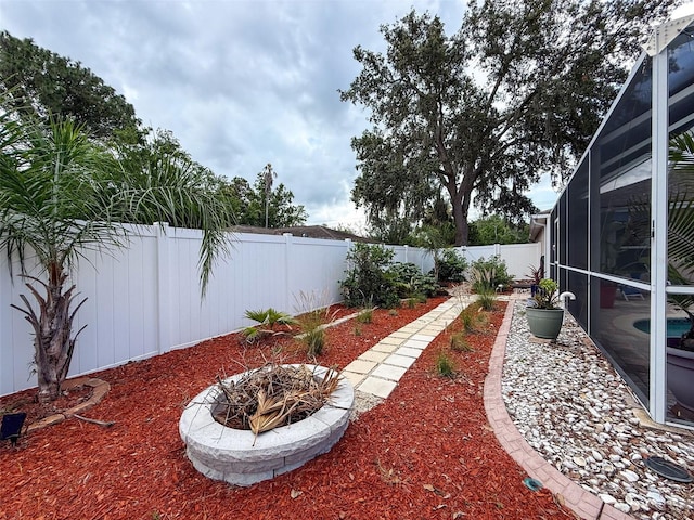9431 Spring Hill Dr, Spring Hill, FL 34608 - fenced backyard with glass enclosure, an outdoor fire pit, and a patio