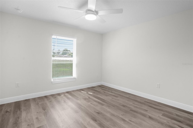5555 Baffin Cir, Spring Hill, FL 34606 - empty room with wood finished floors, ceiling fan, and a smoke detector