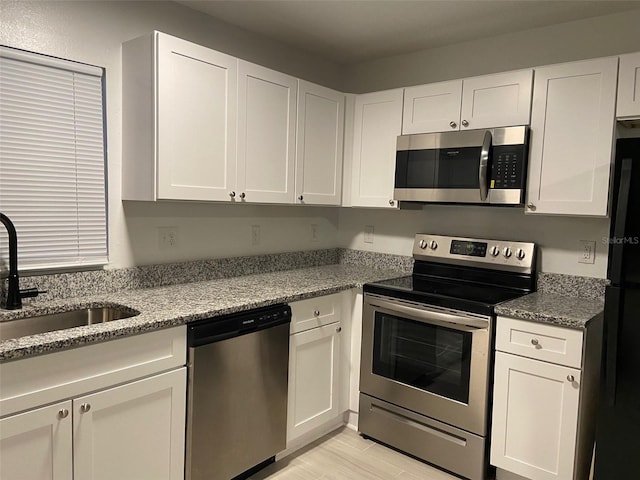 12419 Lamont Ave, New Port Richey, FL 34654 - kitchen featuring appliances with stainless steel finishes and white cabinets
