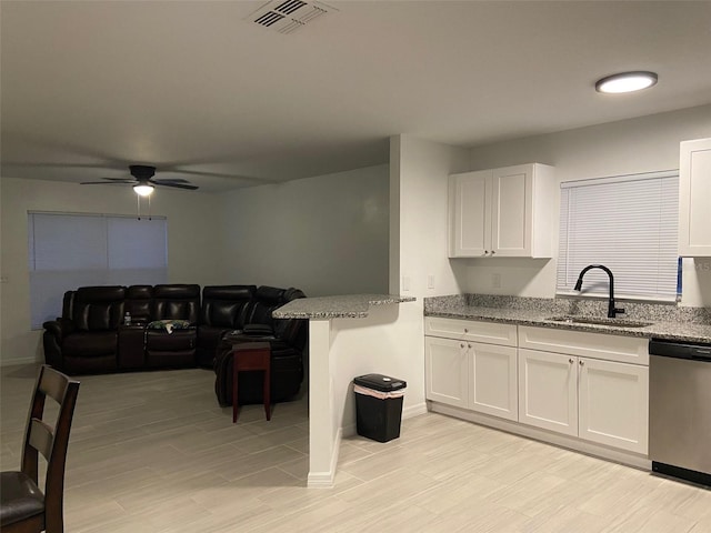 12419 Lamont Ave, New Port Richey, FL 34654 - kitchen with dishwasher, ceiling fan, light stone counters, and white cabinets