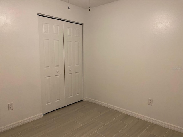 12419 Lamont Ave, New Port Richey, FL 34654 - unfurnished bedroom with wood tiled floors and a closet