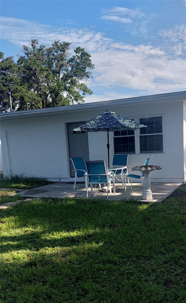 2870 26th Ave N, Saint Petersburg, FL 33713 - rear view of property with a patio, stucco siding, and a yard