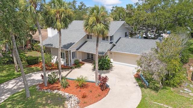 4439 Reeves Rd, New Port Richey, FL 34652 - view of front of property with roof with shingles, driveway, a garage, stucco siding, and a front yard