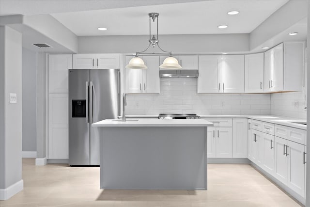 4439 Reeves Rd, New Port Richey, FL 34652 - kitchen featuring stainless steel fridge, white cabinets, light countertops, and recessed lighting