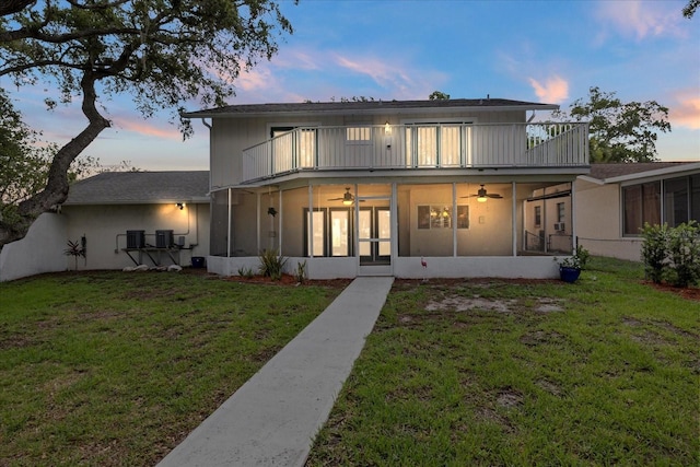 4439 Reeves Rd, New Port Richey, FL 34652 - rear view of property with a balcony, a sunroom, a ceiling fan, and a yard