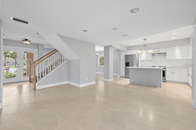 4439 Reeves Rd, New Port Richey, FL 34652 - unfurnished living room with stairs, french doors, and recessed lighting