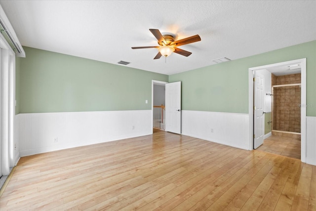 4439 Reeves Rd, New Port Richey, FL 34652 - unfurnished bedroom with hardwood / wood-style floors, a wainscoted wall, ensuite bathroom, and ceiling fan