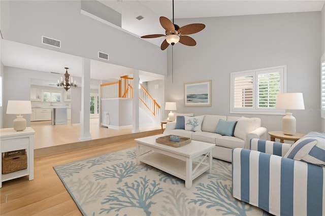 4439 Reeves Rd, New Port Richey, FL 34652 - living area with wood finished floors, stairway, a chandelier, a high ceiling, and a ceiling fan