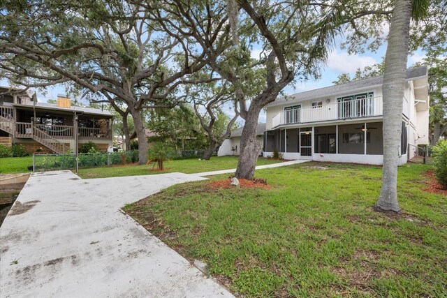 4439 Reeves Rd, New Port Richey, FL 34652 - view of grassy yard featuring a sunroom and a balcony