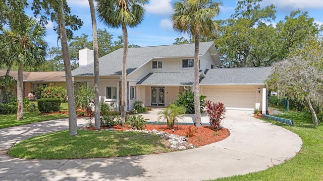 4439 Reeves Rd, New Port Richey, FL 34652 - view of front of property featuring driveway, a garage, a shingled roof, a chimney, and a front yard