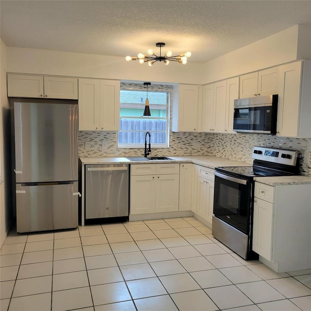 8504 Lafitte Dr, Hudson, FL 34667 - kitchen featuring appliances with stainless steel finishes, a chandelier, light countertops, decorative backsplash, and a textured ceiling