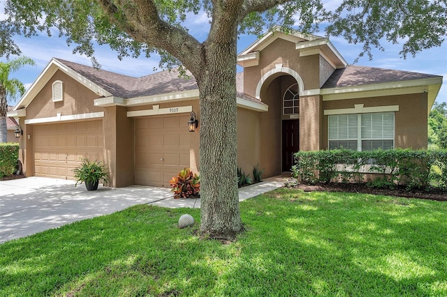 9309 Edistro Pl, New Port Richey, FL 34654 - view of front of home featuring stucco siding, a garage, concrete driveway, and a front lawn