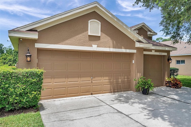 9309 Edistro Pl, New Port Richey, FL 34654 - view of front of home featuring stucco siding, a garage, and concrete driveway