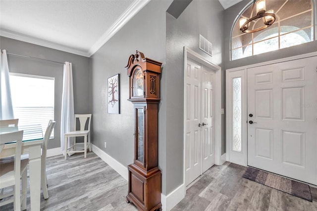 9309 Edistro Pl, New Port Richey, FL 34654 - foyer entrance with ornamental molding, light wood-style floors, and a chandelier