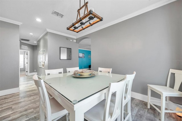 9309 Edistro Pl, New Port Richey, FL 34654 - dining space with arched walkways, ornamental molding, light wood-style floors, and recessed lighting