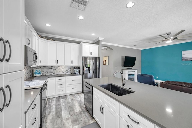 9309 Edistro Pl, New Port Richey, FL 34654 - kitchen with stainless steel appliances, open floor plan, crown molding, a ceiling fan, and white cabinets