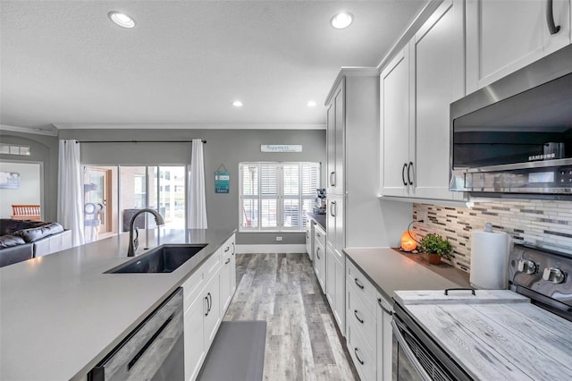 9309 Edistro Pl, New Port Richey, FL 34654 - kitchen featuring stainless steel appliances, light wood-style floors, ornamental molding, decorative backsplash, and recessed lighting