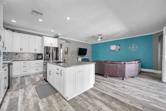 9309 Edistro Pl, New Port Richey, FL 34654 - kitchen featuring stainless steel appliances, ceiling fan, ornamental molding, open floor plan, and arched walkways