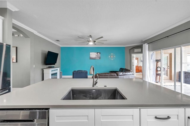 9309 Edistro Pl, New Port Richey, FL 34654 - kitchen with open floor plan, a textured ceiling, crown molding, a ceiling fan, and white cabinets