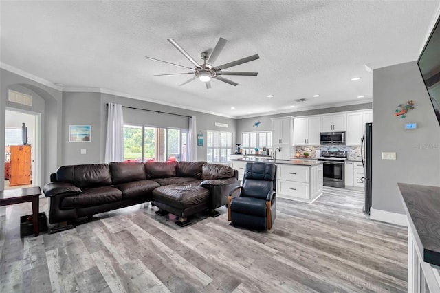 9309 Edistro Pl, New Port Richey, FL 34654 - living area featuring ceiling fan, crown molding, light wood-type flooring, a textured ceiling, and recessed lighting