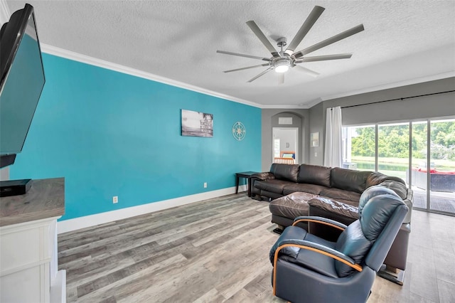 9309 Edistro Pl, New Port Richey, FL 34654 - living area featuring crown molding, ceiling fan, wood finished floors, a textured ceiling, and arched walkways