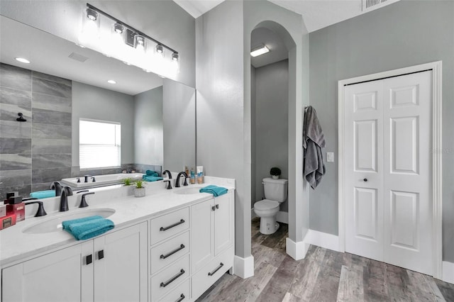 9309 Edistro Pl, New Port Richey, FL 34654 - bathroom with wood finished floors, double vanity, and a garden tub