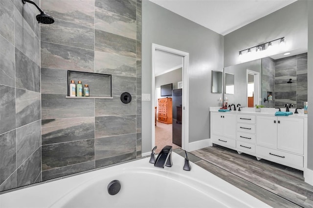 9309 Edistro Pl, New Port Richey, FL 34654 - bathroom featuring a tub to relax in, double vanity, a tile shower, and wood finished floors