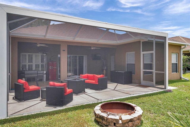 9309 Edistro Pl, New Port Richey, FL 34654 - back of house featuring ceiling fan, an outdoor living space with a fire pit, a patio, and a lawn
