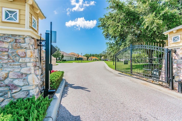 9309 Edistro Pl, New Port Richey, FL 34654 - view of asphalt road featuring a gate and curbs