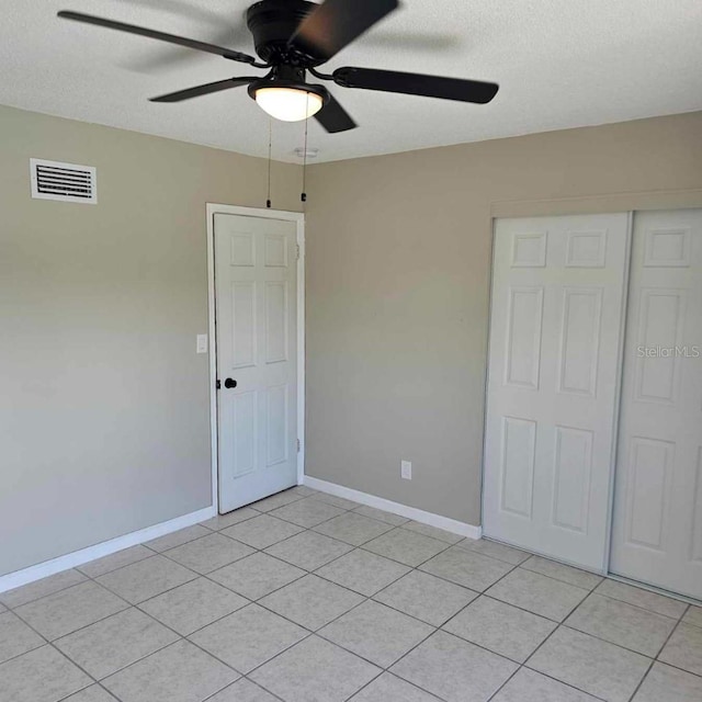 2200 S Palmetto Ave Unit E050, South Daytona, FL 32119 - unfurnished bedroom featuring light tile patterned floors, a closet, ceiling fan, and a textured ceiling