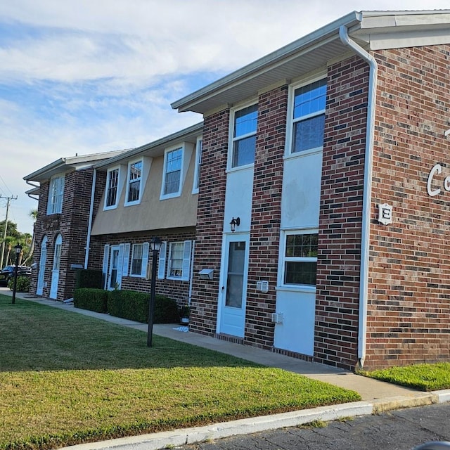 2200 S Palmetto Ave Unit E050, South Daytona, FL 32119 - view of front of home featuring a front yard, brick siding, and stucco siding