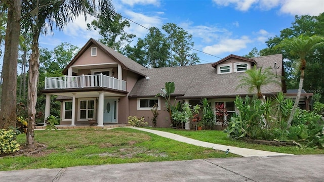 2202 Amity Ct, New Port Richey, FL 34655 - view of front of home with a balcony, roof with shingles, a front yard, and stucco siding