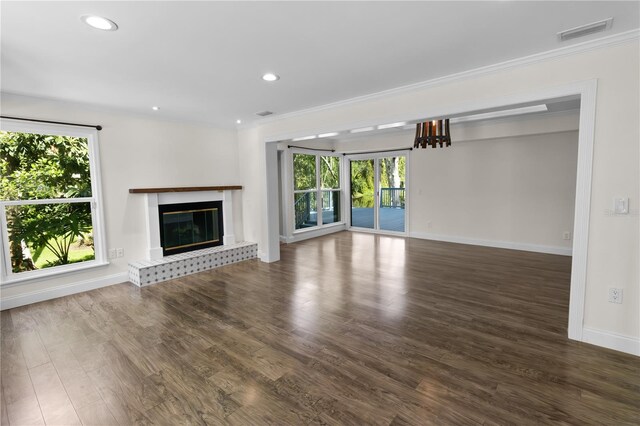2202 Amity Ct, New Port Richey, FL 34655 - unfurnished living room with crown molding, a glass covered fireplace, wood finished floors, and recessed lighting