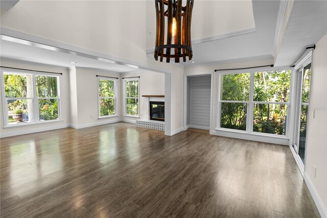 2202 Amity Ct, New Port Richey, FL 34655 - unfurnished living room featuring wood finished floors, a brick fireplace, and ornamental molding