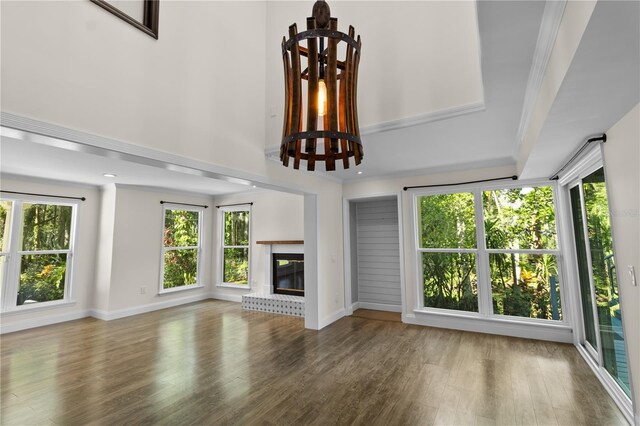 2202 Amity Ct, New Port Richey, FL 34655 - unfurnished living room featuring wood finished floors, a brick fireplace, and crown molding