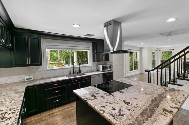 2202 Amity Ct, New Port Richey, FL 34655 - kitchen featuring island exhaust hood, appliances with stainless steel finishes, tasteful backsplash, healthy amount of natural light, and recessed lighting