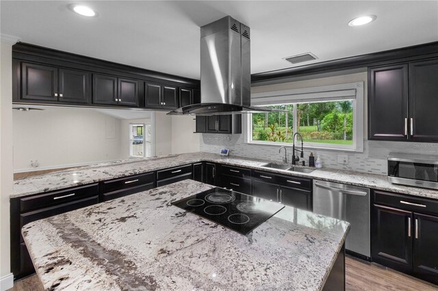 2202 Amity Ct, New Port Richey, FL 34655 - kitchen featuring stainless steel appliances, island range hood, dark cabinets, light wood-style flooring, and recessed lighting