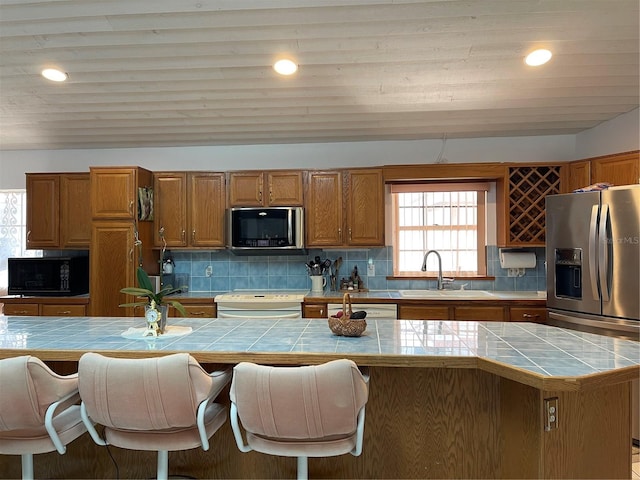 20971 Negril Ct, Lutz, FL 33558 - kitchen with black microwave, tile counters, brown cabinets, and recessed lighting
