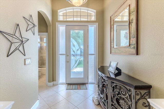 9406 Burnam Dr, Weeki Wachee, FL 34613 - entrance foyer featuring arched walkways, light tile patterned flooring, and a textured wall