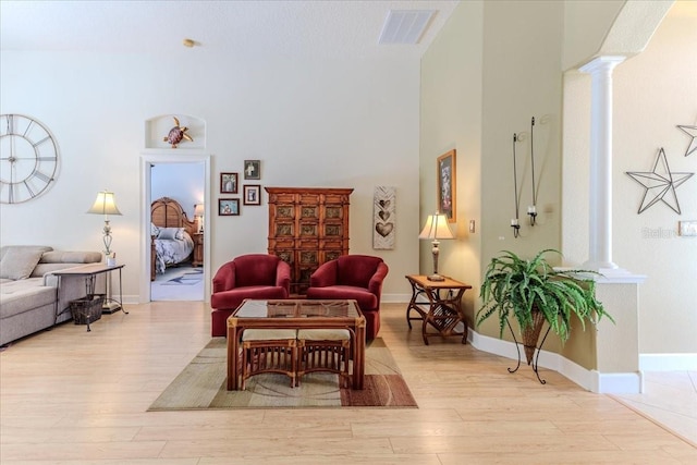 9406 Burnam Dr, Weeki Wachee, FL 34613 - living room with decorative columns, wood finished floors, and a high ceiling