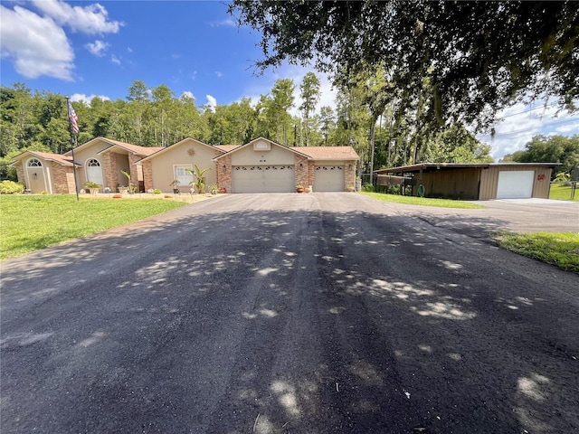 10060 Chip Ln, New Port Richey, FL 34654 - view of front of house with driveway, a front yard, a garage, an outdoor structure, and view of wooded area