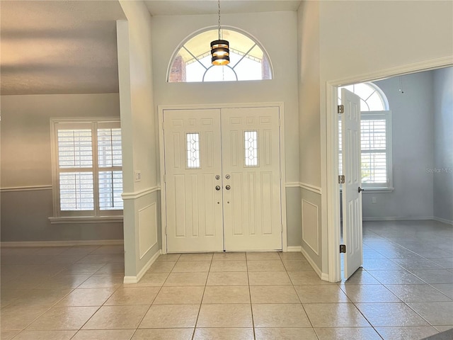 10060 Chip Ln, New Port Richey, FL 34654 - foyer with light tile patterned floors, wainscoting, and a high ceiling